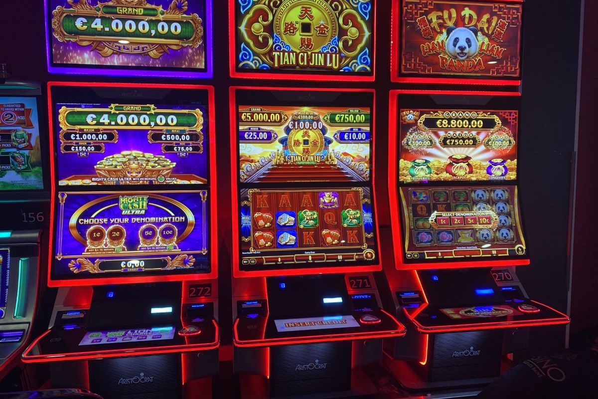 Trois machines à sous vidéo Aristocrat au casino de Saint-Gilles, écrans affichant les jackpots Grand, Major, Minor et Mini