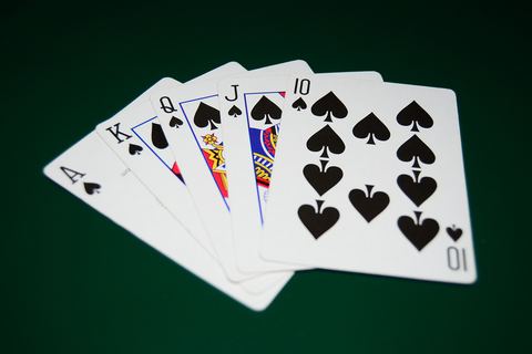 Quinte flush royale à pique étalée sur un tapis vert